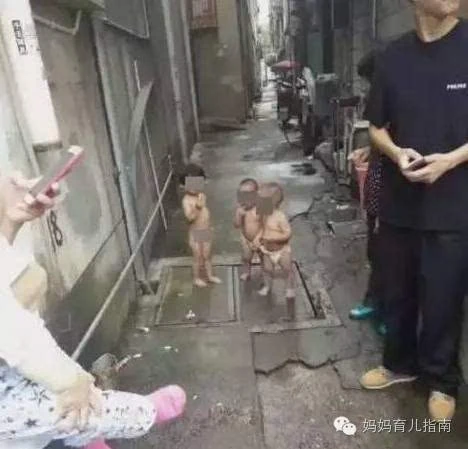 正优哉游哉地吃着棒棒糖……一个光屁股的小女娃和两个穿着尿不湿的