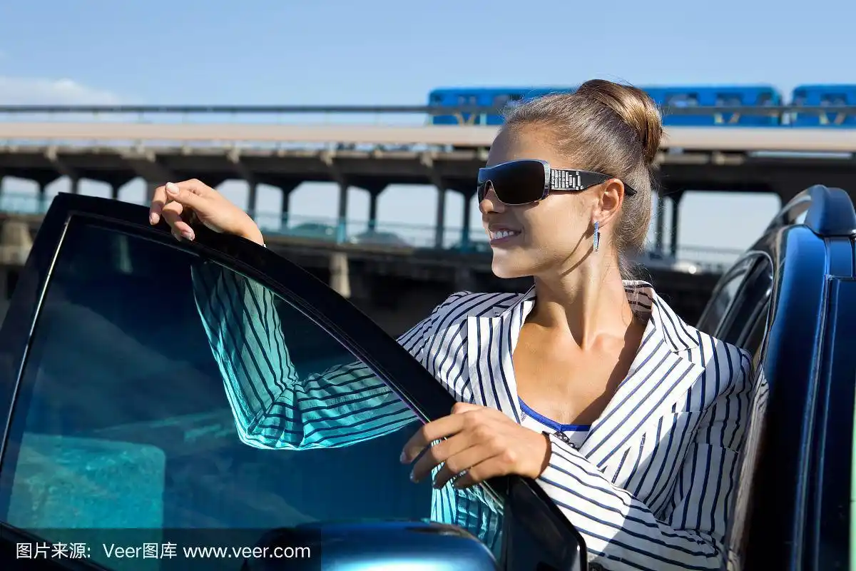 在车旁边戴墨镜的女人