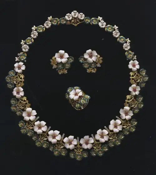 这是一套以花为元素设计的首饰套件,白色和蓝色的花朵用景泰蓝装饰