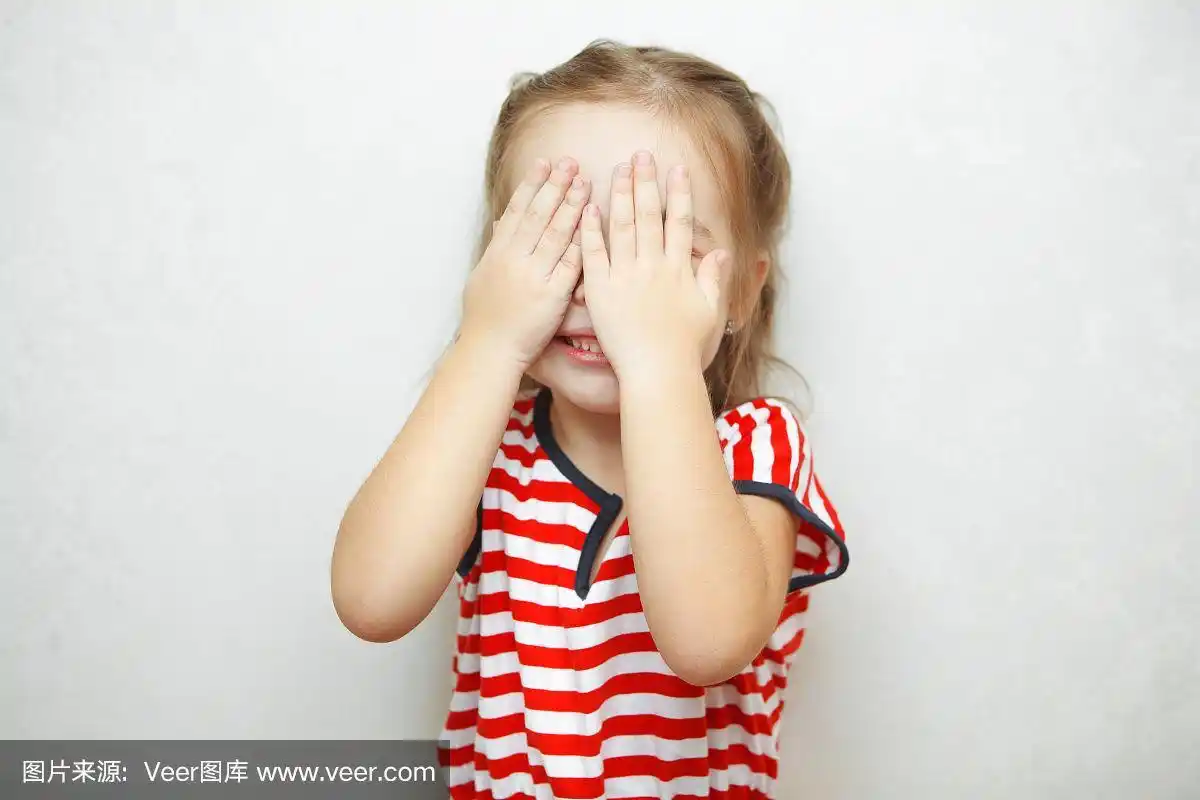 可爱的小女孩用手掌捂着脸