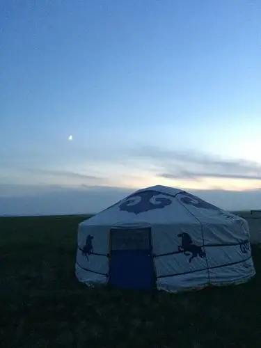 月亮升上了蒙古包,夜晚,银河浩瀚,星光璀璨,天地间一片静谧.