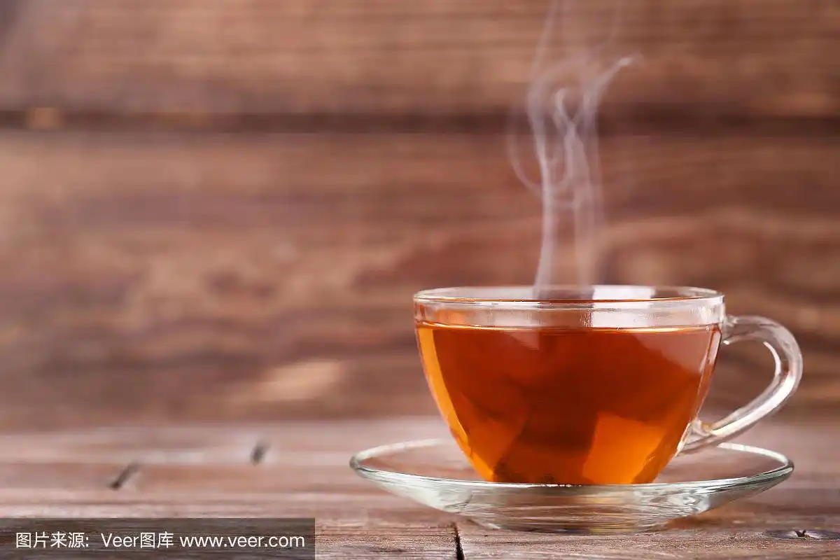 棕色的木桌上放着一杯热气腾腾的茶