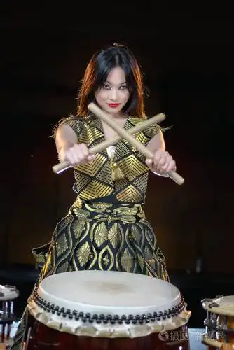亚洲长发鼓手美女鼓棒工作室拍摄一个黑暗的背景