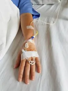 手输液病人手上有滴管输液针和静脉插管.照片