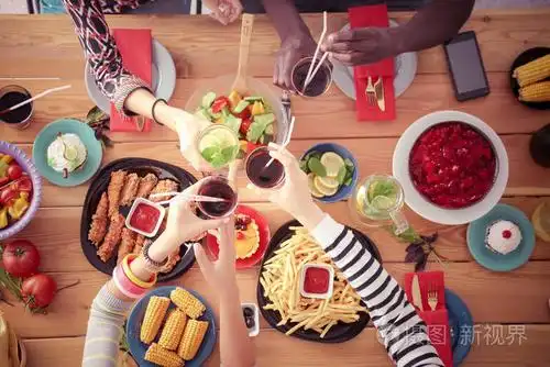 顶视图的一群人在一起时坐在木桌吃饭在桌子上的食物人们吃快餐