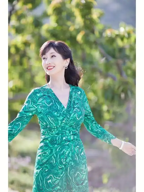 演员赵雅芝,身着dvf 2022春夏系列绿色大理石花纹图案连衣裙