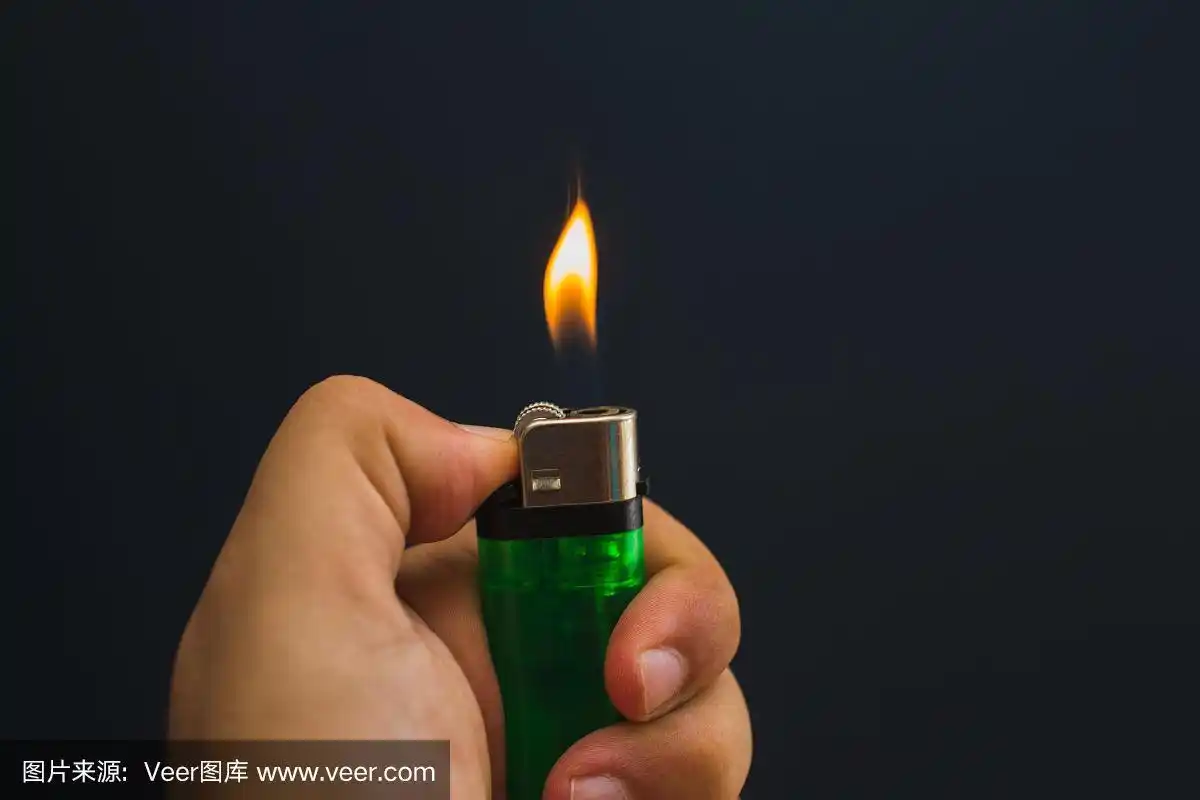 一个手持燃烧气体打火机的特写视图.