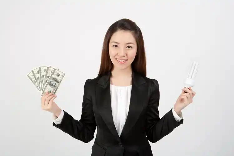 手拿钞票与灯泡的美女高清图片图片[高清图片,jpg格式]