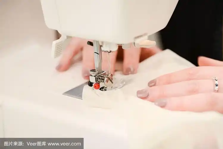 在缝纫机上工作的年轻女裁缝合上双手