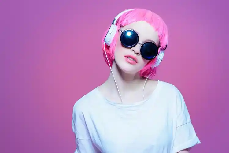 时尚的女孩戴墨镜享受音乐