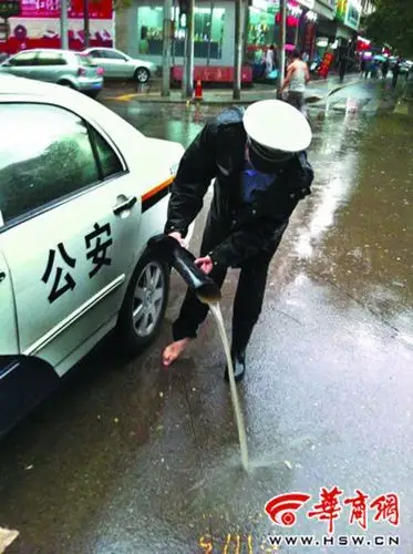 新城大队交警杨浩在尚勤路十字执勤时,雨水灌满了雨靴