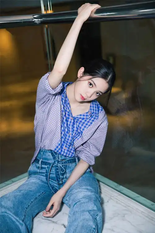 照片中欧阳娜娜身穿清新格纹衬衫搭配蓝色牛仔裤,鞋底小花点缀,细节之