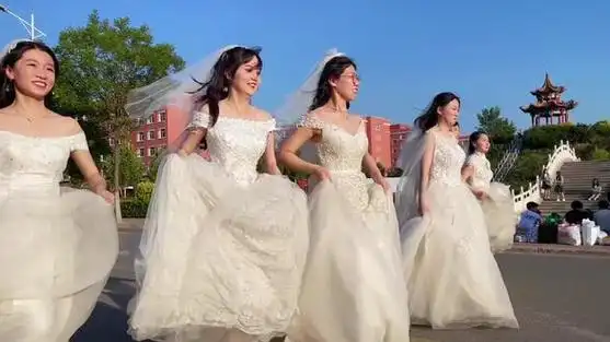 学生穿婚纱到学校去拍毕业照