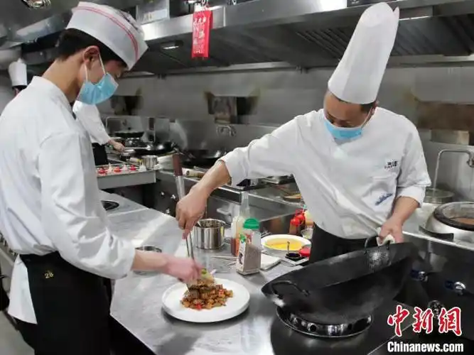 厨师正在将刚出锅的菜肴进行装盘 李明明 摄