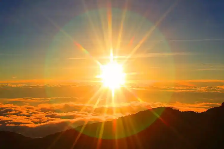 清晨的太阳笼罩在山那边的低云之上图片下载