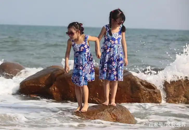 2月15日,小朋友在三亚海边戏水游玩.