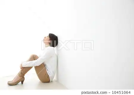 双臂抱膝坐於地板上