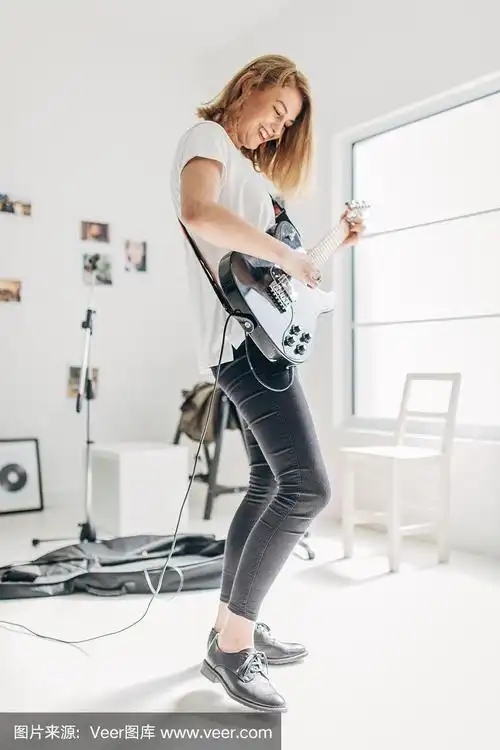 美丽的女士在音乐工作室独自弹电吉他