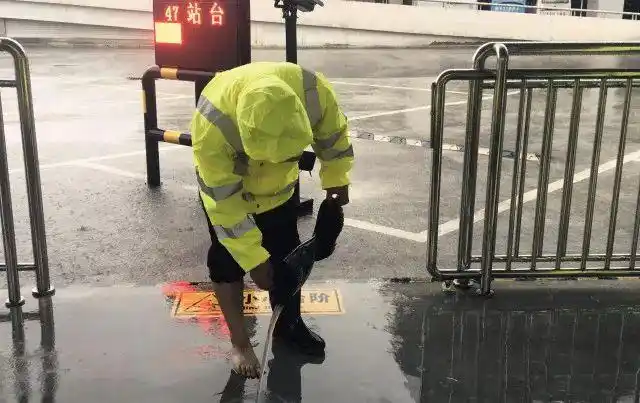 即便是雨靴,也抵挡不住这暴雨的肆虐工作人员开启窨井盖设立防护设施