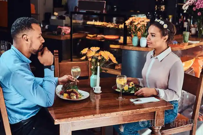 一对迷人的情侣享受对方, 在餐厅吃饭