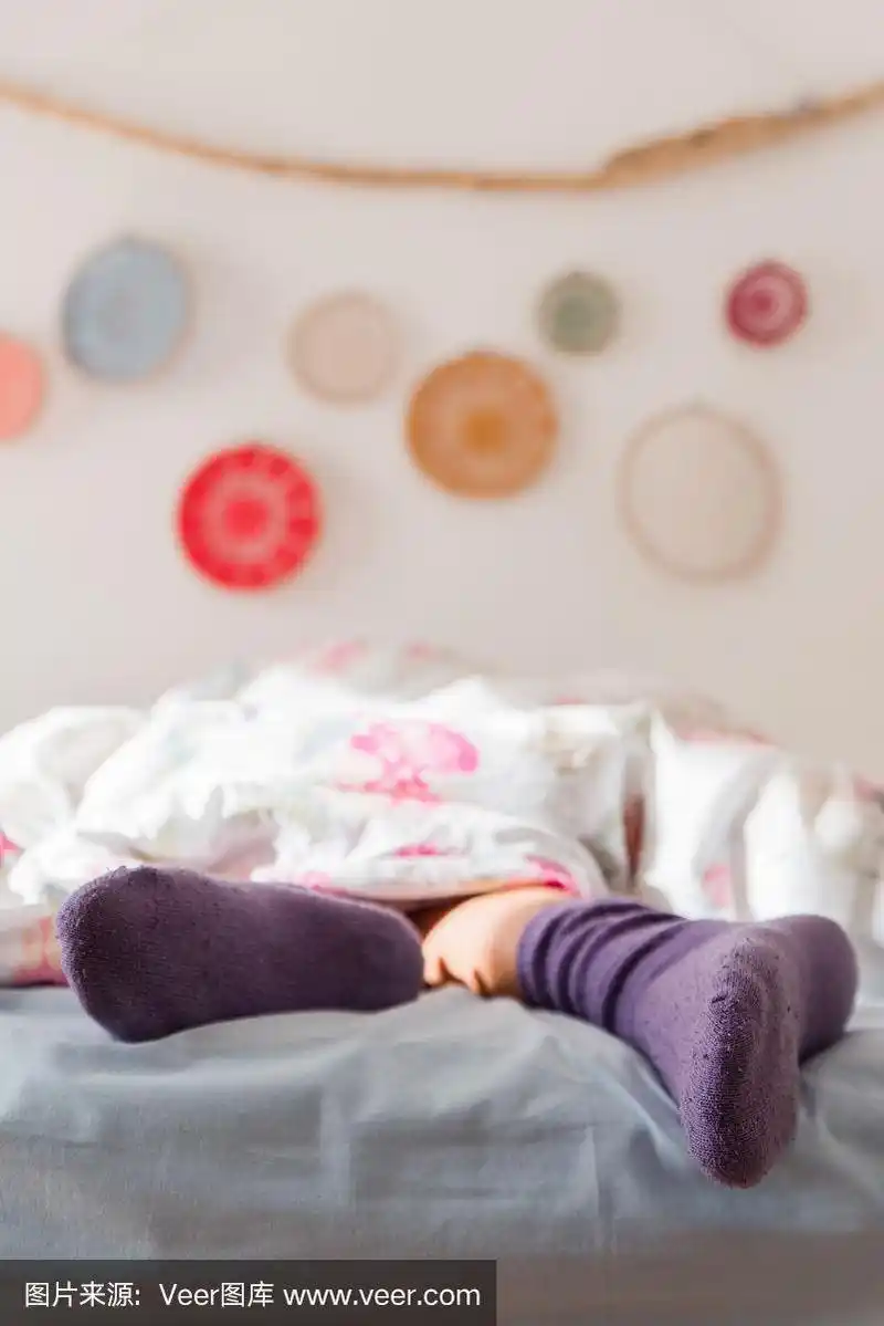 女人的脚在温暖的羊毛袜子,女人睡觉和放松在床上