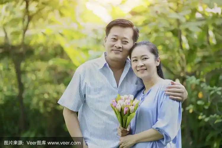 可爱的老年夫妇幸福的亚洲丈夫拥抱妻子,拿着郁金香花,照顾和照顾一起