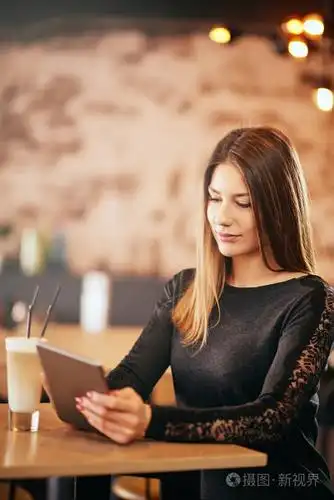 年轻的白种女人坐在咖啡馆喝咖啡时使用片剂