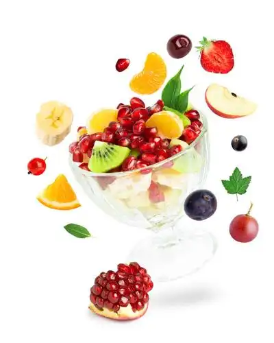 白色背景下有杯托的玻璃杯装着的新鲜水果