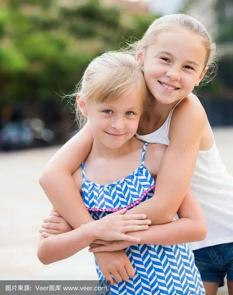 两个微笑的小女孩拥抱在一起
