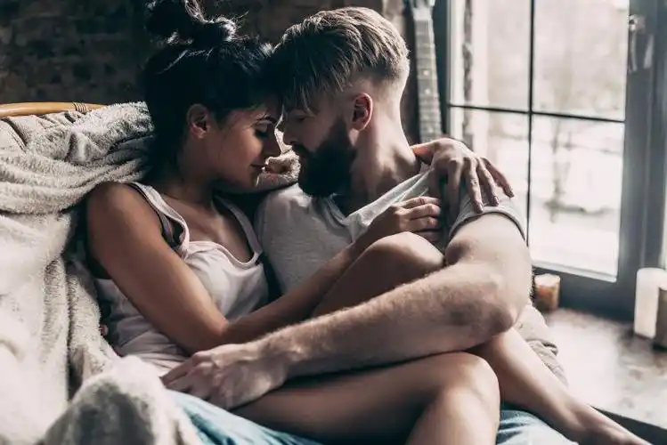 年轻夫妇在椅子上面对面拥抱