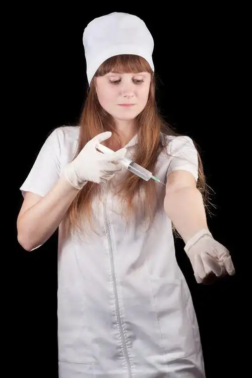 护士,护士举行注射器在黑色背景上的手.