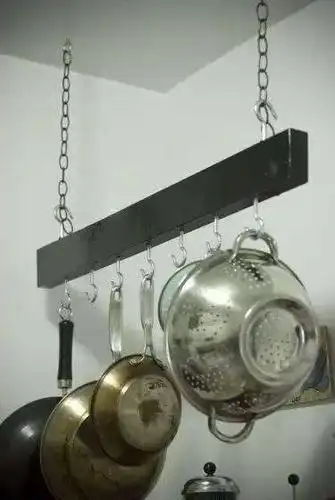 用不着放那么多锅具的,吊一根木头在墙角,挂上锅具多省事.