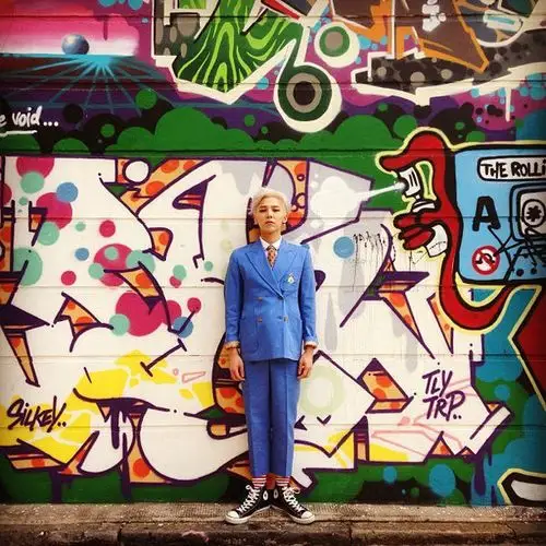 一张gd 权志龙 crooked 蓝色西服图片 站在一个涂鸦墙前