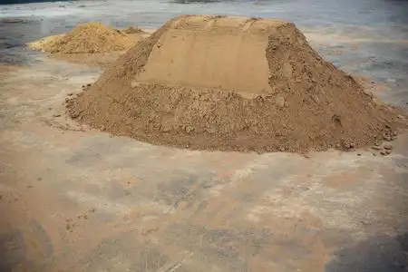 施工设备,施工照片混凝土搅拌机安装在建筑工地旁边一堆沙子和砾石