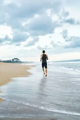 照片 健身男人在海滩上运行.赛跑者在户外锻炼慢跑.jpg