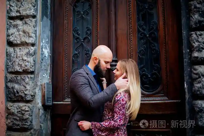 环抱的一个美丽的时尚情侣贴近对方户外秋季街头上楼梯阳光灿烂的日子