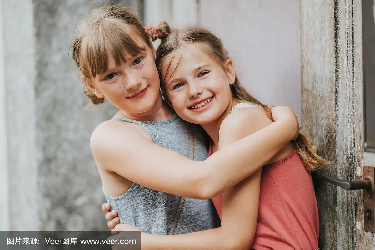 两个可爱的小女孩相互拥抱的夏季肖像