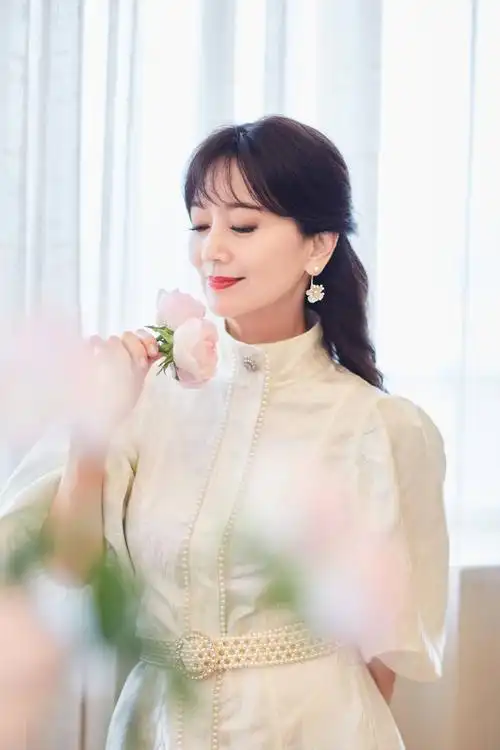 赵雅芝白色泡泡袖短裙秀美腿 持粉色玫瑰人比花娇