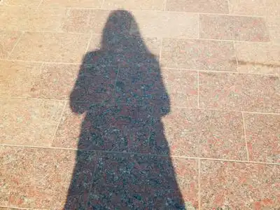 一个人在大理石板上的影子.人行道上的人的影子照片