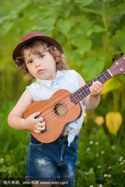 小女孩在户外弹奏尤克里里.