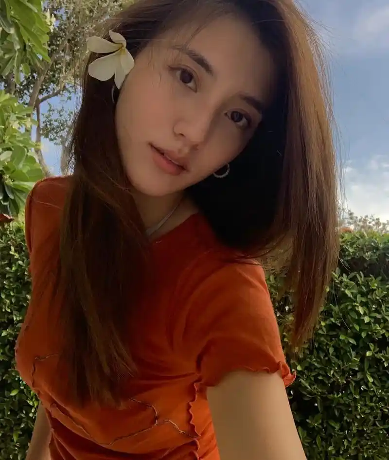 吴千语海边度假拍美照,耳朵上别着花瓣自拍太唯美,她坐在岸边礁石上凹