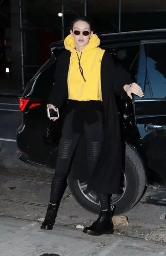 gigi一身黑的造型,被一件黄色的卫衣点亮了,黑配黄的撞色穿搭,还能显