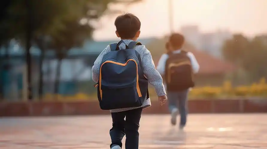 背着书包上学的小学生孩子背影学校校园开学季教育学生学习成长