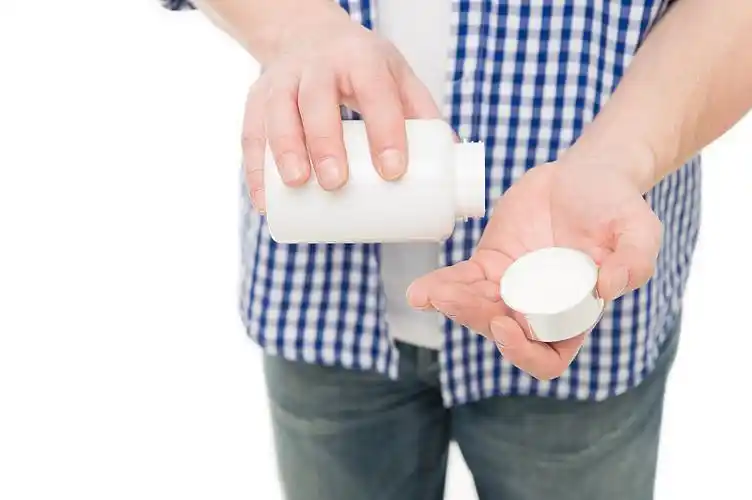 维生素补充剂的概念.男性手中拿着药瓶或维生素.成人复合维生素.