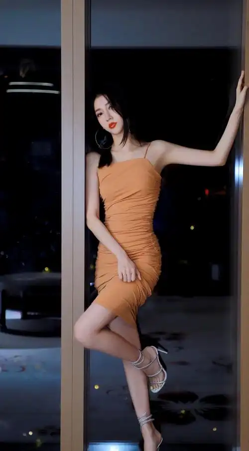 弦子穿橙色吊带裙配银色绑带高跟,露出白皙美腿,身材傲人