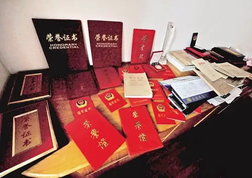 李益波的各种奖状摆满了一桌子.