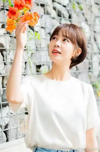 崔允英穿纯色白t恤牛仔裤拍照,青春减龄撩发弄花显温柔知性范