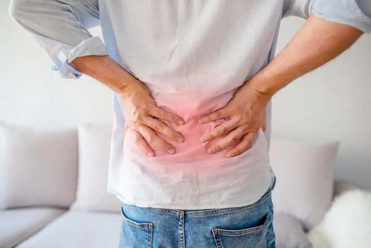 后视图的年轻人抱着他疼痛的腰部腰酸背痛