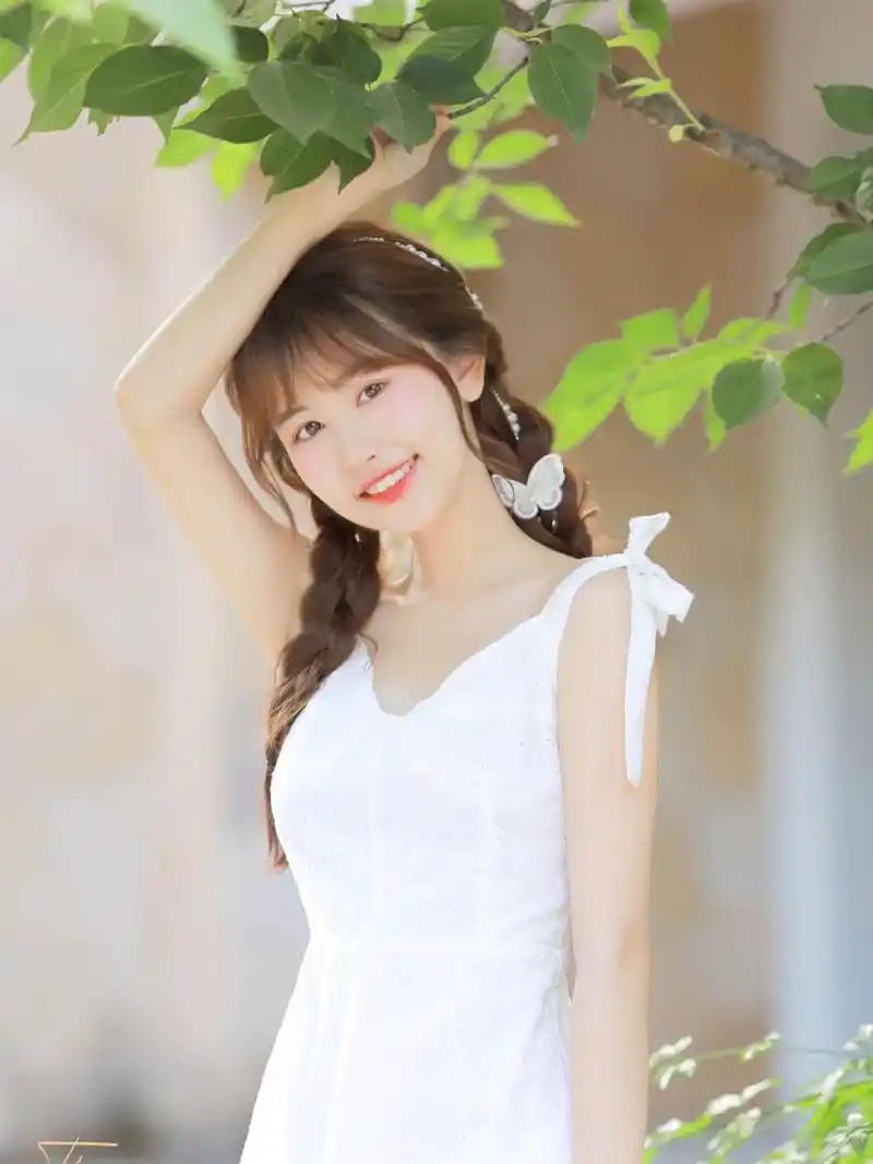 青春阳光的女孩穿一身白色长裙,好像邻家女孩,懂事青春的样子