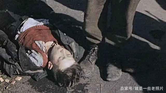 1945年,捷克斯洛伐克,美军士兵在围观路边的一个死亡的德国娃娃兵.
